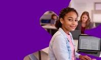 Imagem de menina sentada em frente ao notebook e sorrindo.