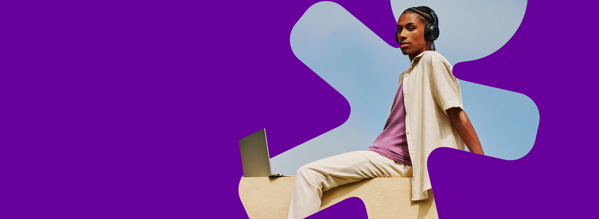 Jovem, homem, pele negra, sentado em frente a um notebook.